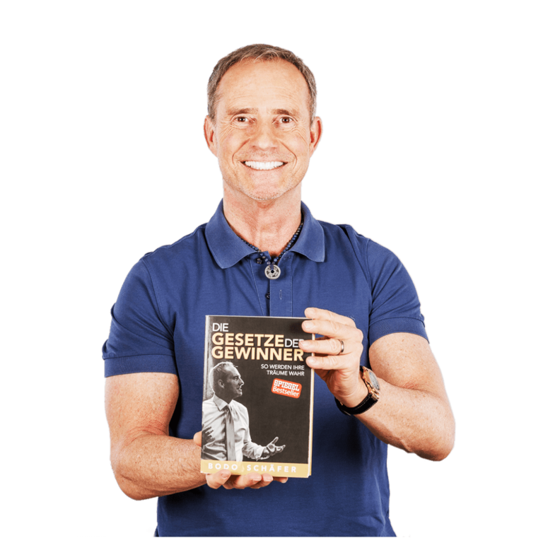 Bodo Schäfer mit seinem Buch "Gesetze der Gewinner" in der Hand